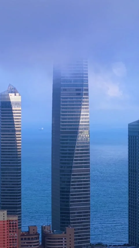 Qingdao City Skyscraper Emerging from Clouds, Ocean View Stock Footage 330949419