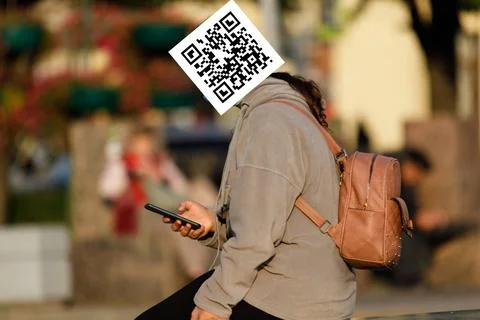 Qr code on the face of a person holding a phone in his hand Stock Photos
