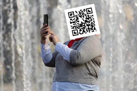 Qr code on the face of a person holding a phone in his hand Stock Photos