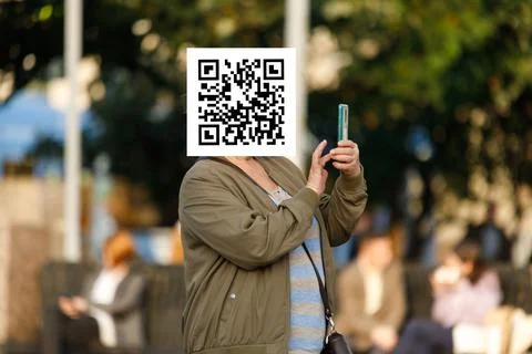 Qr code on the face of a person holding a phone in his hand Stockfoto's