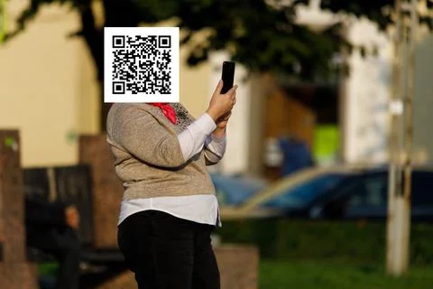Qr code on the face of a person holding a phone in his hand Stockfoto's