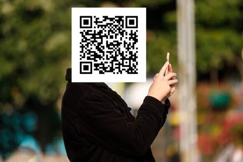 Qr code on the face of a person holding a phone in his hand Stockfoto's