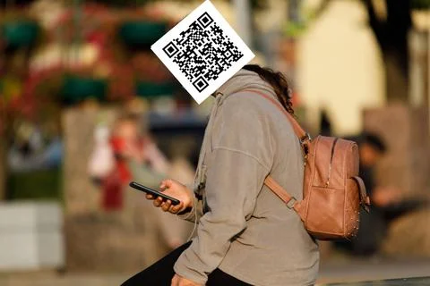 Qr code on the face of a person holding a phone in his hand Stock Photos