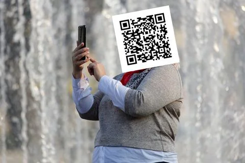 Qr code on the face of a person holding a phone in his hand Stockfoto's