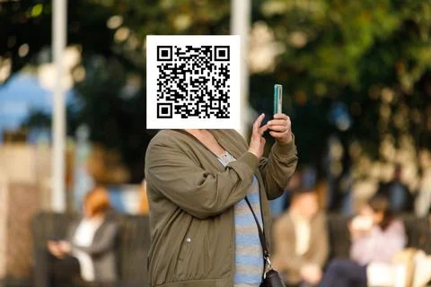 Qr code on the face of a person holding a phone in his hand Stock Photos