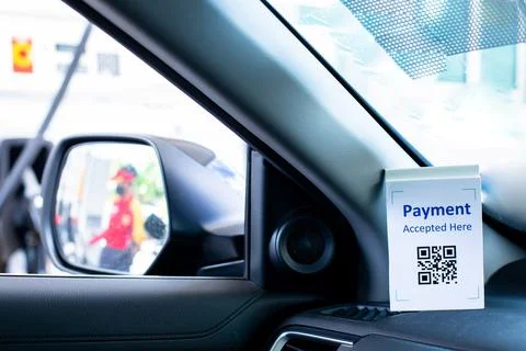 QR code payment tag with blurry image on wing mirror of staff  in gas station Stock-Fotos