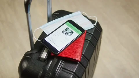 QR code on smartphone, medical mask and passport on suitcase. Vaccination Stock-Footage 166102573