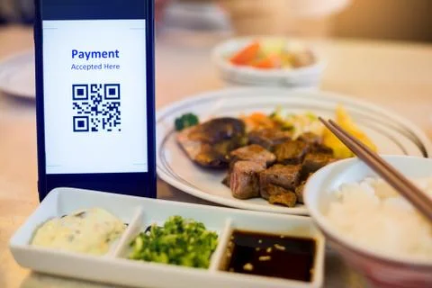 QR code tag on smartphone with blurry japanese food and dessert in restaurant Stock Photos