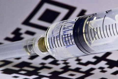 QR-code of vaccination shines through a disposable plastic syringe Stock Photos