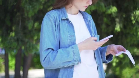 QR Scan. The girl scans the code on a check from the store, outside Stock Footage 131756730