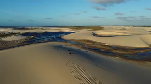 Quad Bikes Crossing dunes of Lençóis Maranhenses at sunset Stock Footage 339804540