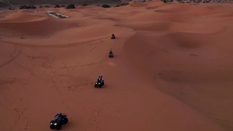 Quad bikes crossing Erg Chebbi sand dunes at sunrise in Sahara Desert on aerial Stock Footage 339044406