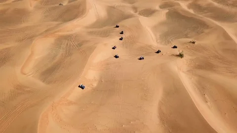 Quad bikes heading toward sand dunes in Dubai - Aerial 動画素材 107092809