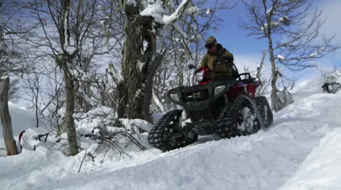 Quad riding over snowy mountain road Stock Footage 27844573