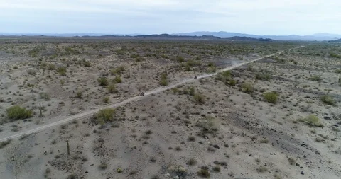 Quadbikers speeding along dirt path through desert in Arizona drone aerial 4K Stock Footage 111310313