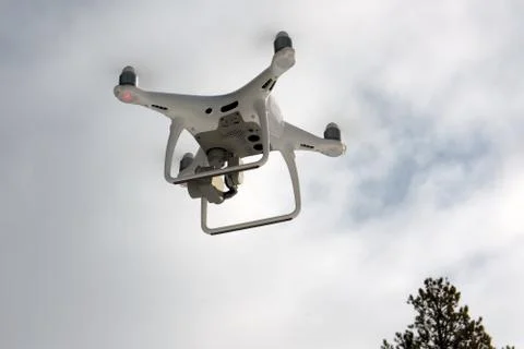 Quadcopter on the background of forest and clouds. Stock Photos