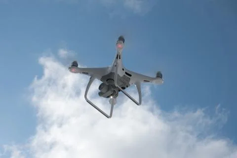 Quadcopter on the background of forest and clouds. Stock Photos