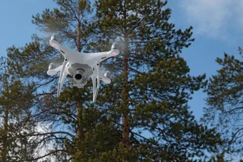 Quadcopter on the background of forest and clouds. Stock Photos