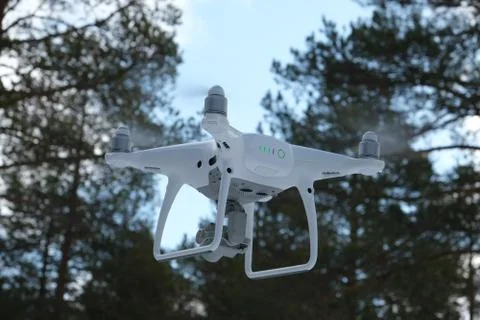 Quadcopter on the background of forest and clouds. In the background are forest, Stock Photos