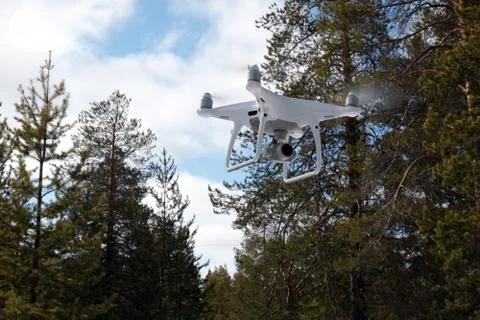 Quadcopter on the background of forest and clouds. Stock Photos