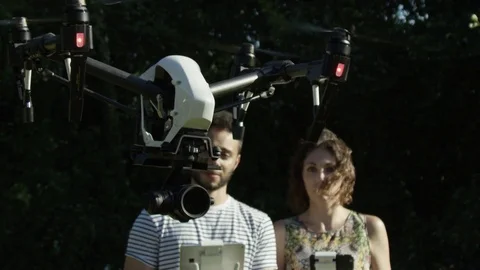 Quadcopter With Camera and Two Hipster Millennial Pilots With Remote Controllers Видео 82594813