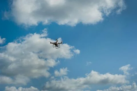 Quadcopter with camera in blue sky with clouds Stock Photos