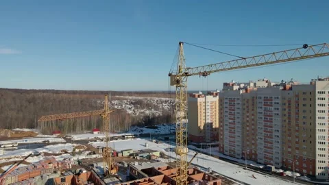 The quadcopter descends parallel to the construction crane. View of a building Stock Footage 151875783