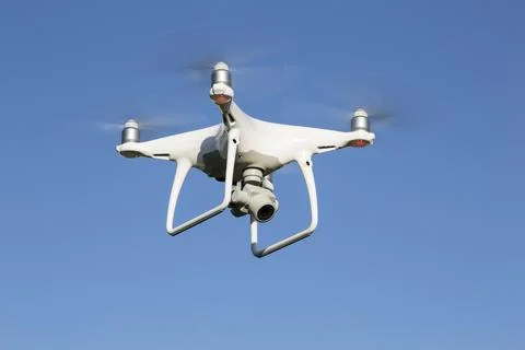 The quadcopter with the digital camera in flight Stock Photos