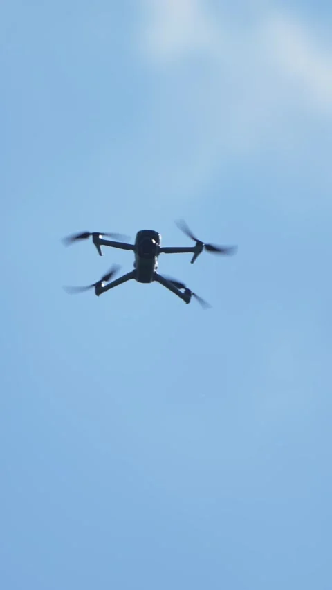 Quadcopter drone flying in clear sky with visible propellers, aerial technology Stock Footage 332218873