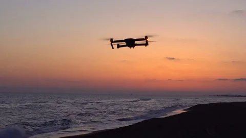 Quadcopter drone flying in the sunset at the beautiful sea landscape. Stock Footage 80252828
