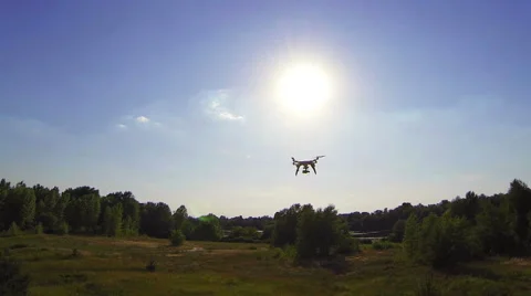 Quadcopter-drone is flying up through the sun. Aerial Stock-Footage 40616511