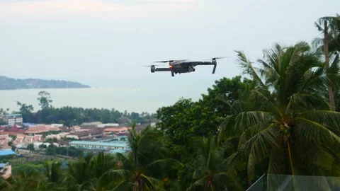 Quadcopter drone hovering and flying on sky background Stock Footage 197464021