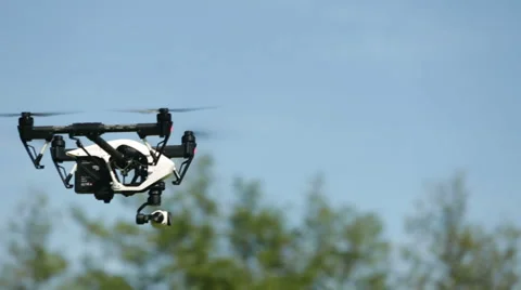 Quadcopter / Drone hovering on a sunny day in a park Stock Footage 58625883