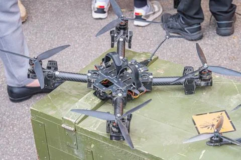 A quadcopter drone is lying on its side atop a green storage container in an  스톡 사진