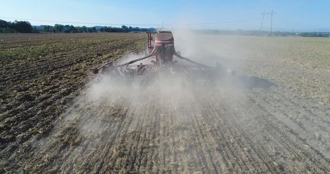 The quadcopter flies behind the tractor irrigating the fields. background Stock Footage 126587458