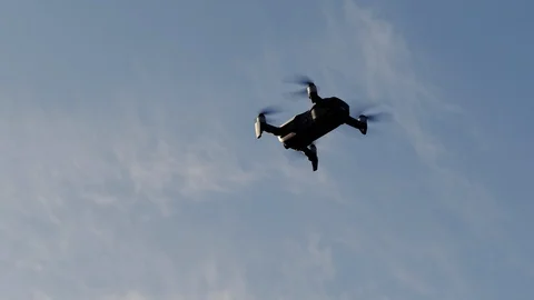 Quadcopter flies in the blue sky, drone shoots video Stock Footage 118433322
