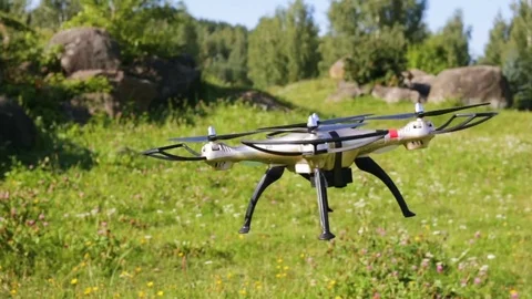 Quadcopter flies low in front of the camera. Close-up, outdoors, summer, warm, n Stock Footage 84913639