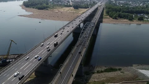 Quadcopter flies over bridge with dense car traffic and flies towards the city. Stock Footage 127893381