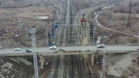The quadcopter flies over the bridge over the railway Stock Footage 151252712