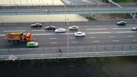 Quadcopter flies over next to a bridge with heavy traffic situation Stock Footage 127894480