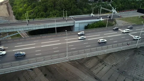 Quadcopter flies over next to a bridge with heavy traffic situation. Stock Footage 127894483