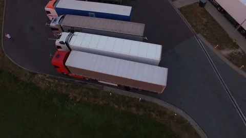 Quadcopter flying fast above trucks standing in rows on parking place close up  Stock Footage 96238904