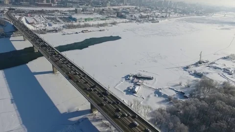 Quadcopter flying over a highway bridge across the Ob river. Video stock 77129196