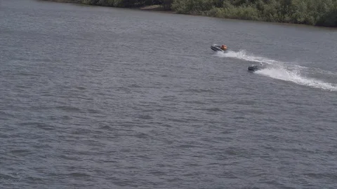 Quadcopter flying over the river at a time when the river float two boats. Stock Footage 129308784