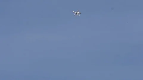 Quadcopter flying in the sky in the far distance Stock Footage 79184979