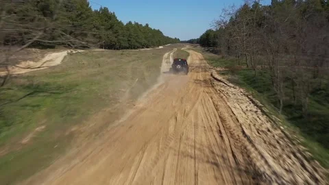 The quadcopter at high speed flies behind a buggy UTV through the forest Stock Footage 159474127