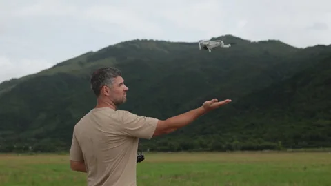 A quadcopter lands on a mans palm. Video stock 320689482