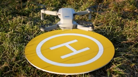 Quadcopter lands on yellow platform. Landing place in the grass. Sunny day.Ba Vídeos de archivo 150125583