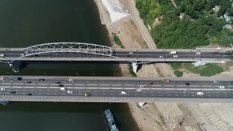 Quadcopter rises from two-lane bridge and removed from the city along the river. Stock Footage 127893409
