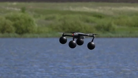 Quadcopter in slow motion hovering over water Stock Footage 125874794